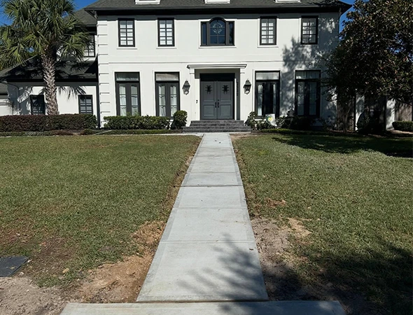 Newly installed concrete driveway connecting to a residential sidewalk in West University