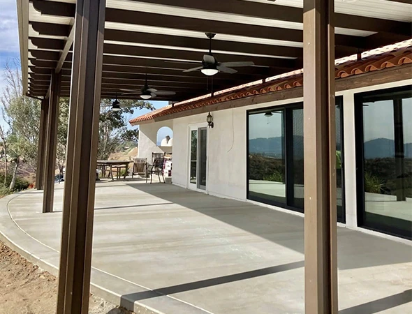 Finished wood pergola with shade cloth over an outdoor living space